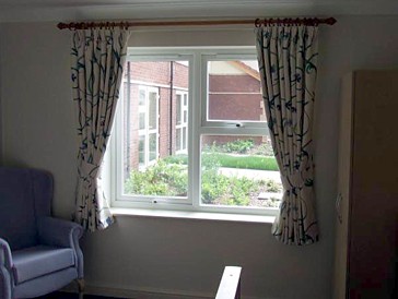 Curtains with tie backs in a typical care home bedroom